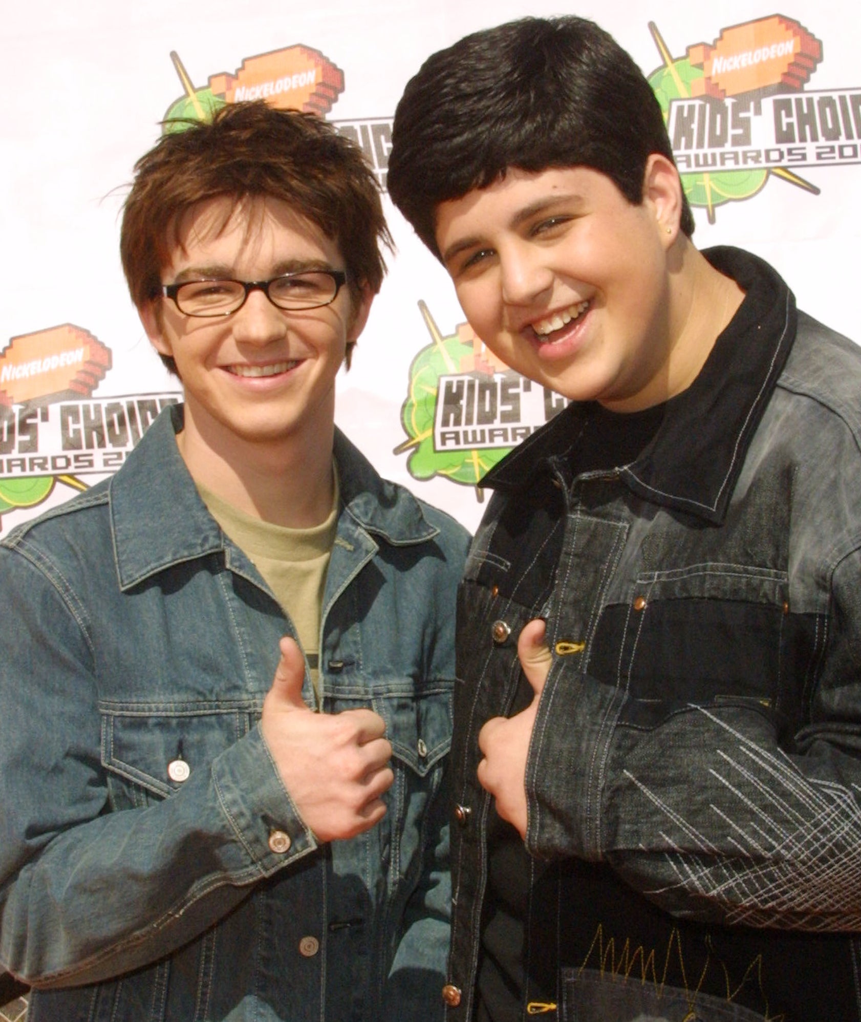 Drake Bell and Josh Peck giving a thumbs up while posing for photographers at an event
