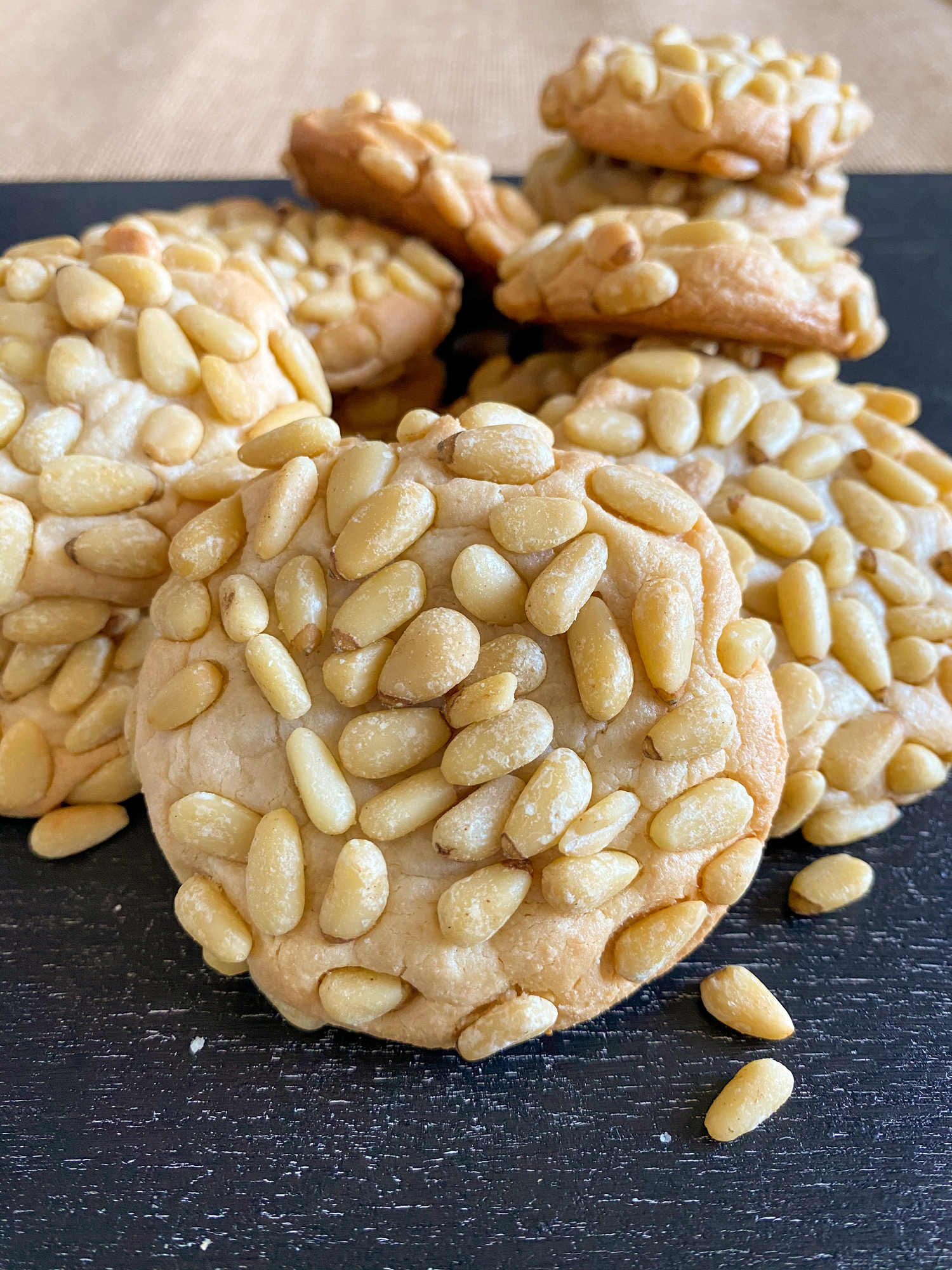 Close-up of pine nut cookies on a dark surface