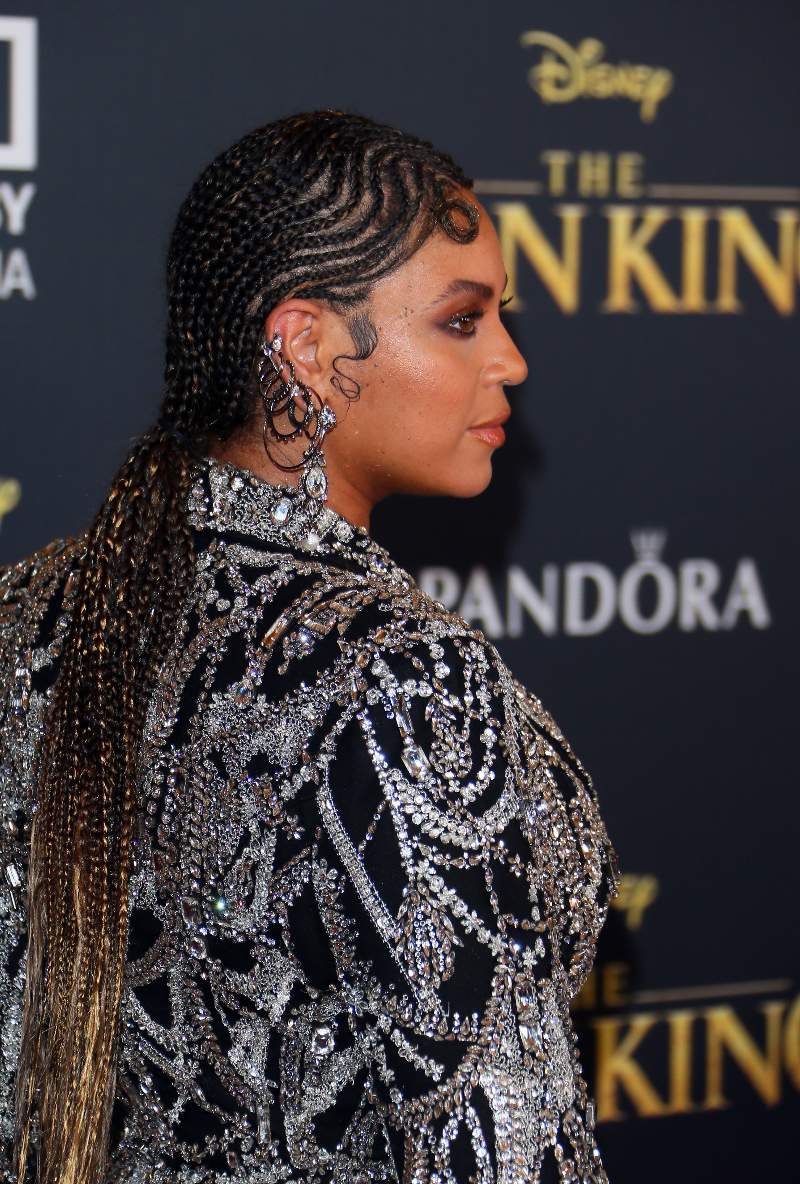 Beyoncé in a beaded dress with intricate patterns, at the Lion King premiere rocking another braided hairstyle