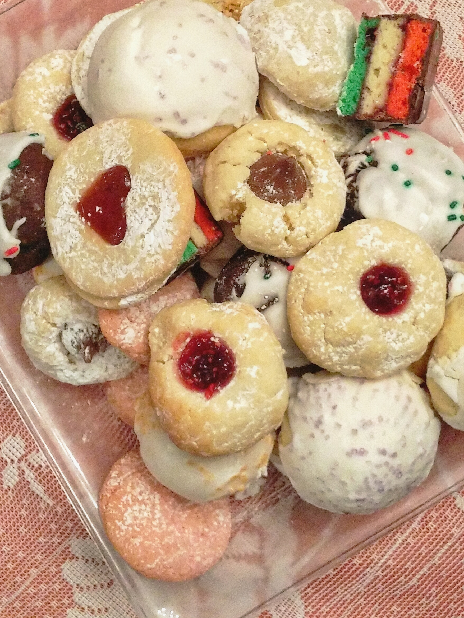 An assortment of homemade cookies including jam-filled and chocolate-dipped varieties on a plate