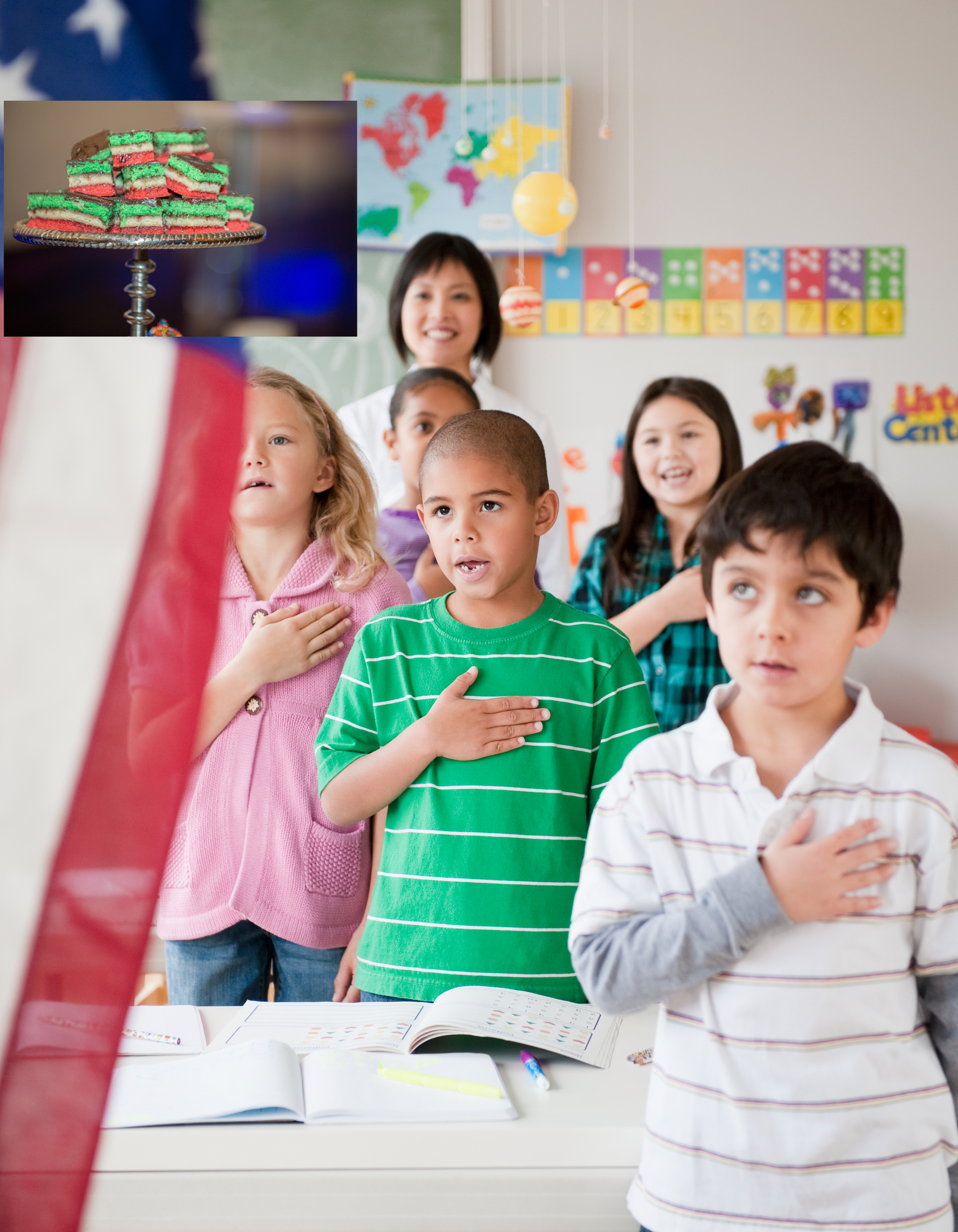 Children in a classroom with hands on hearts, facing the US flag, likely during the Pledge of Allegiance
