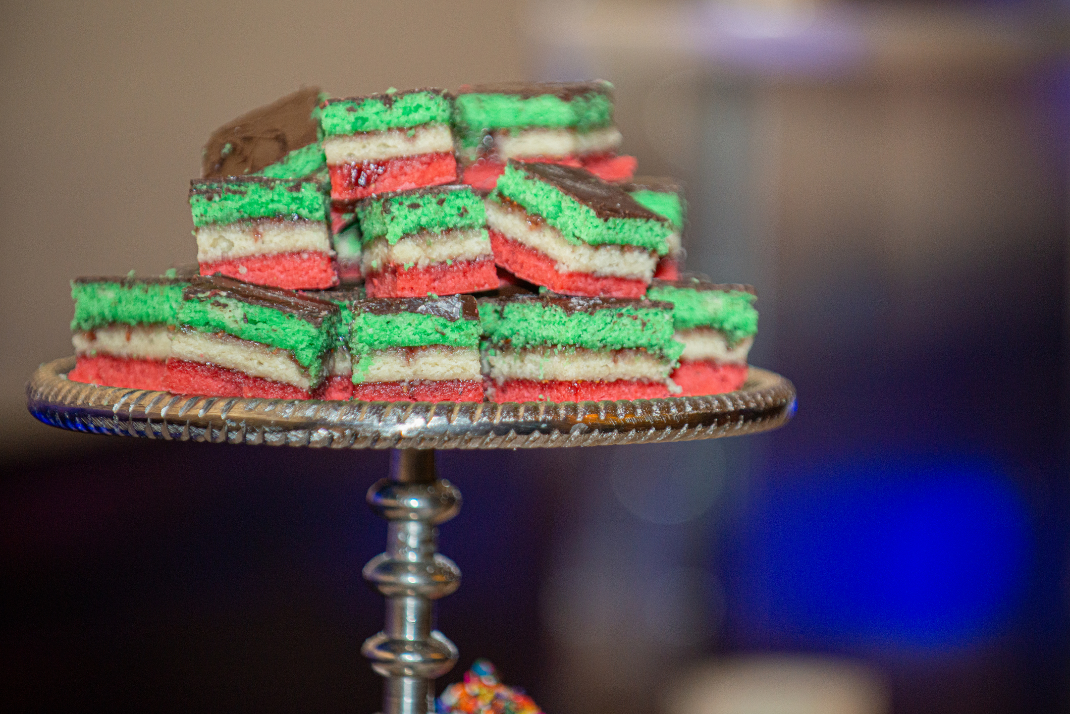 A layered rainbow cake displayed on a cake stand