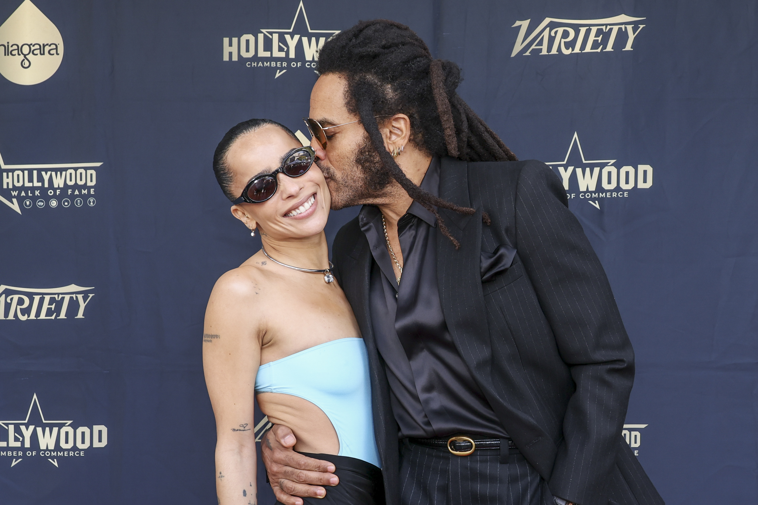 A closeup of Lenny Kravitz kissing Zoë on the cheek