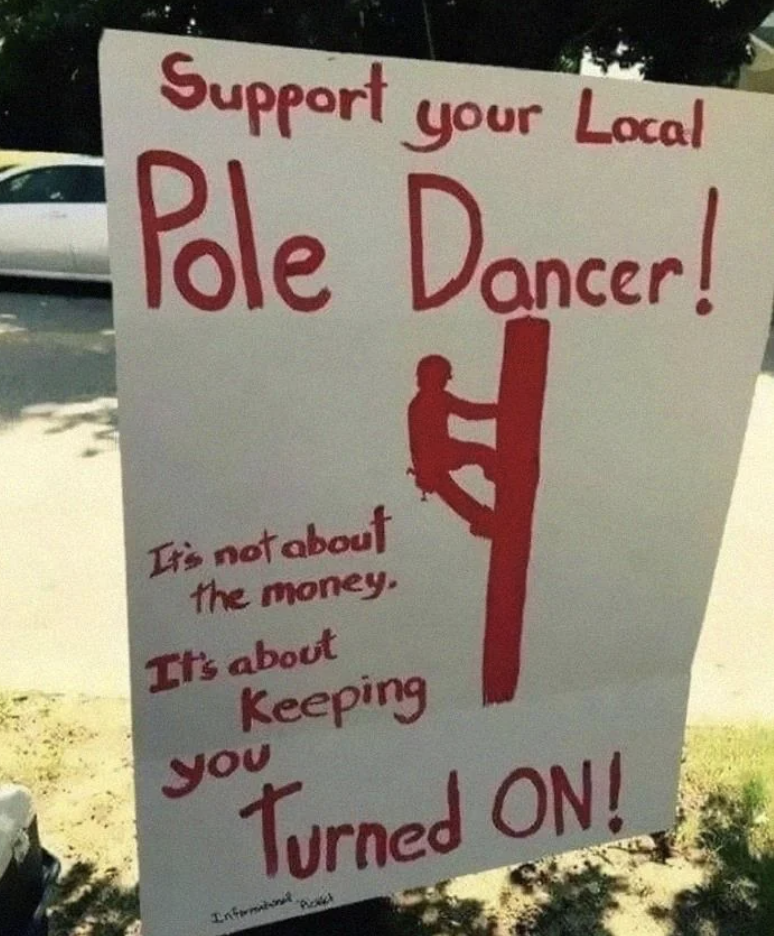 Sign reads &quot;Support your Local Pole Dancer!&quot; with humorous subtext about keeping people energized