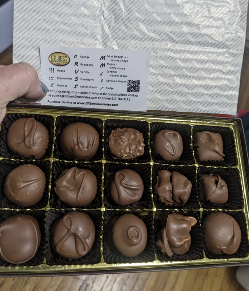 Assorted chocolates in a box with a flavor guide card on top