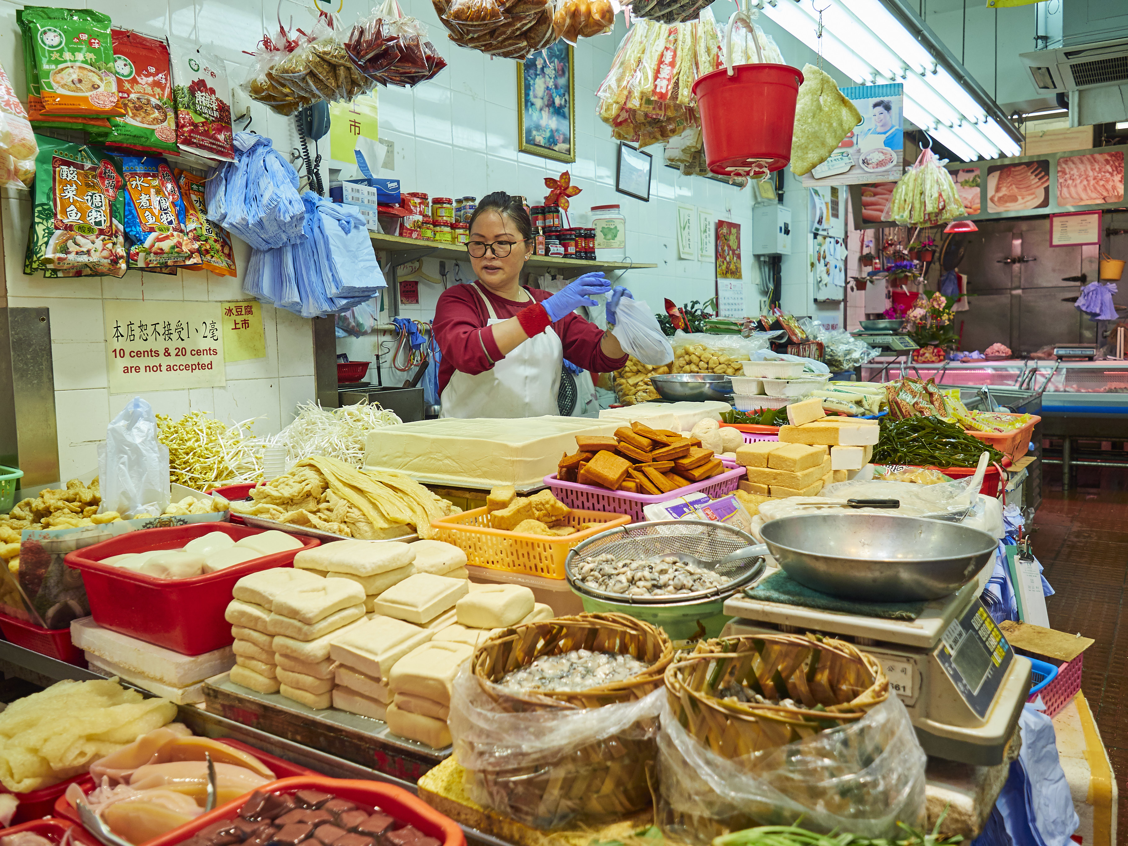 Vendor arranging various tofu types at a traditional market stall