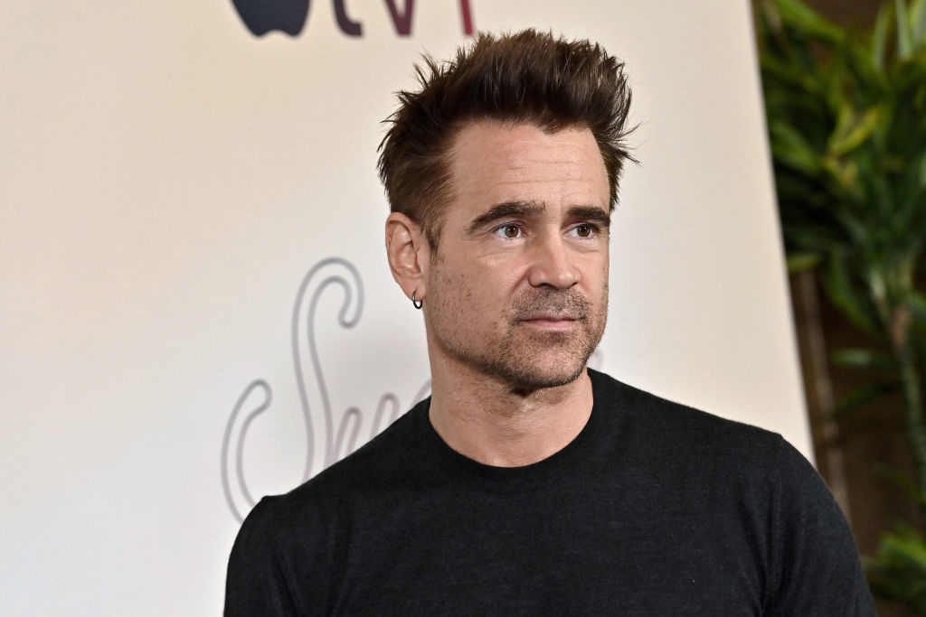 Colin Farrell stands in a black crewneck t-shirt at an event