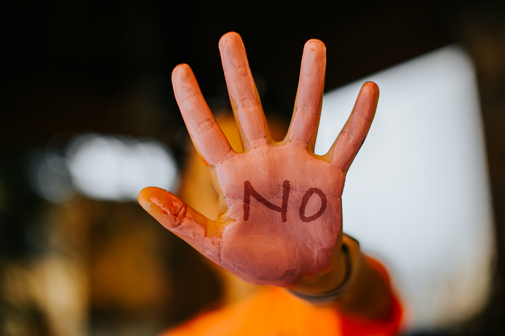 Person&#x27;s hand facing forward with &quot;NO&quot; written on the palm, expressing refusal or boundary setting