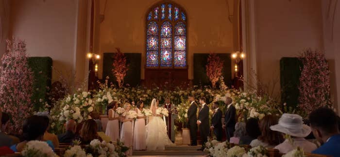 A wedding ceremony inside a church with a couple at the altar and guests seated