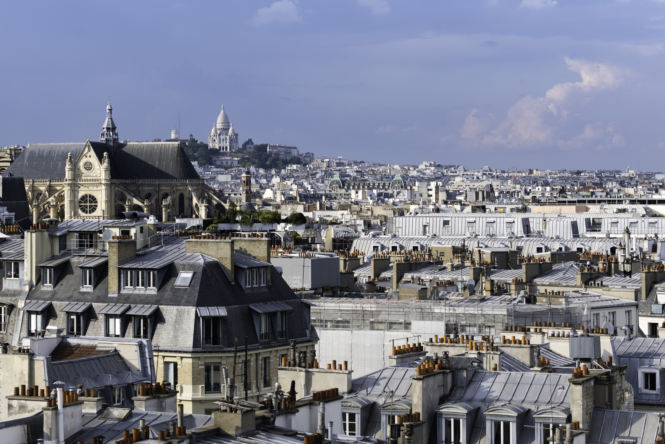 Rooftop view of Paris architecture with the Sacré-Cœur Basilica in the distance