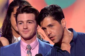 Drake Bell and Josh Peck on stage by a microphone looking forward