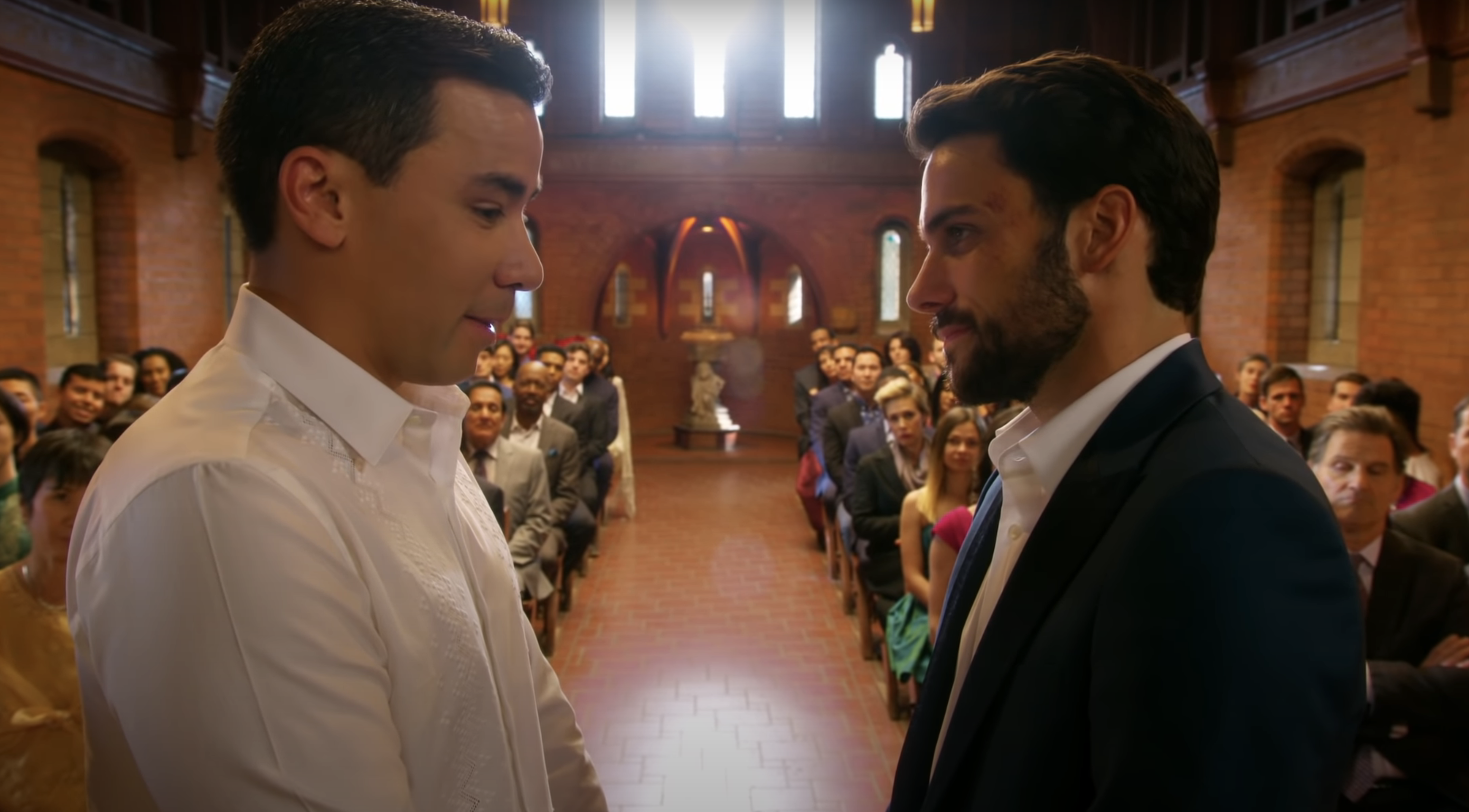 Two man standing at the altar in front of friends and family