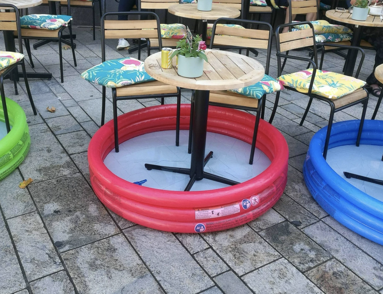 Outdoor cafe tables set in large inflatable pools for physical distancing