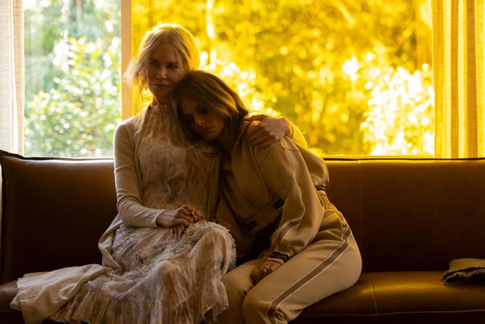Nicole Kidman and Melissa McCarthy sit closely on a couch in a scene from a TV show or movie