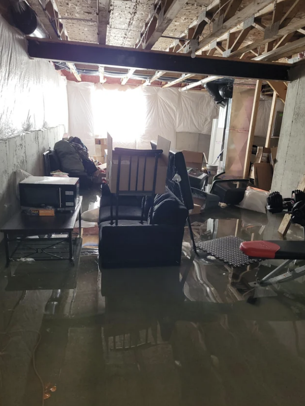 A flooded basement with furniture and items submerged in water