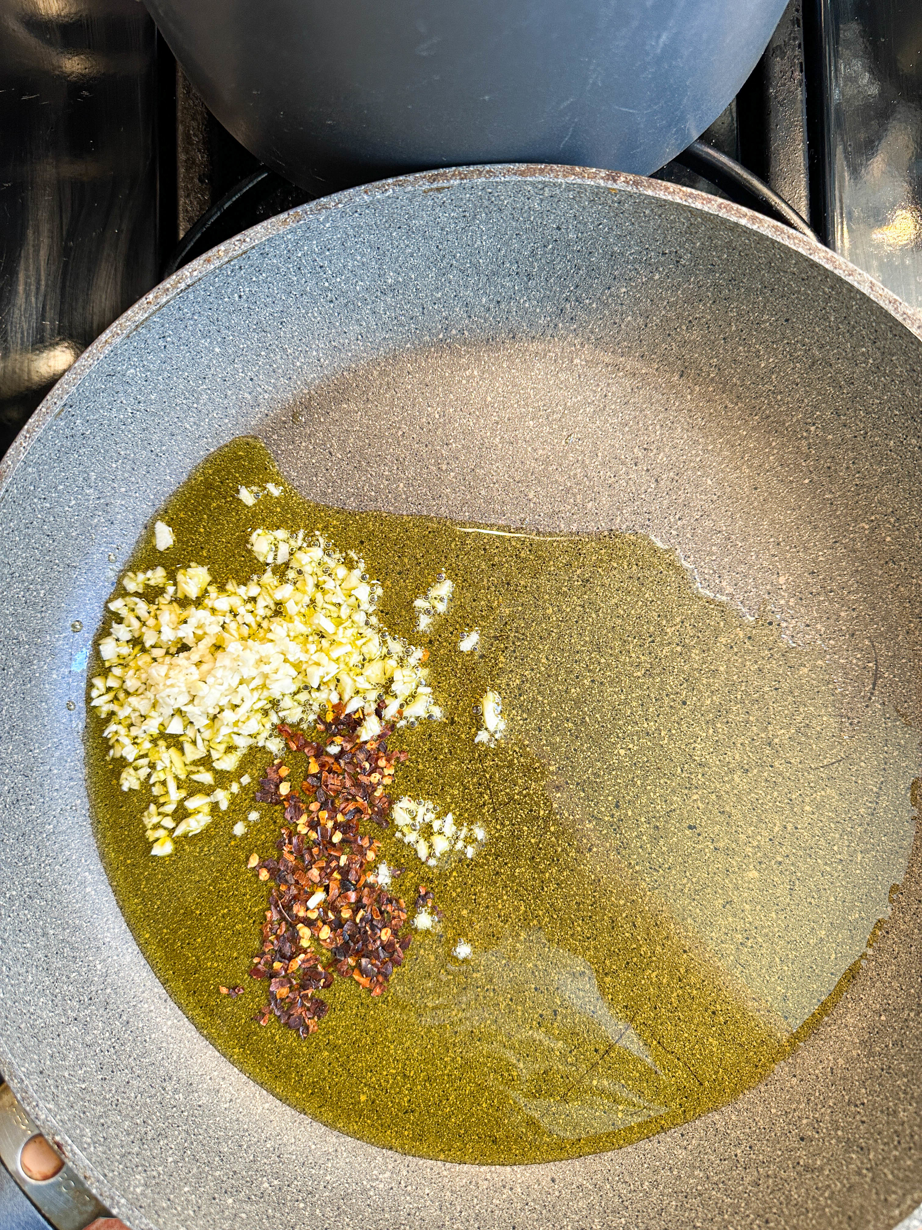 Oil, minced garlic, and chili flakes in a frying pan