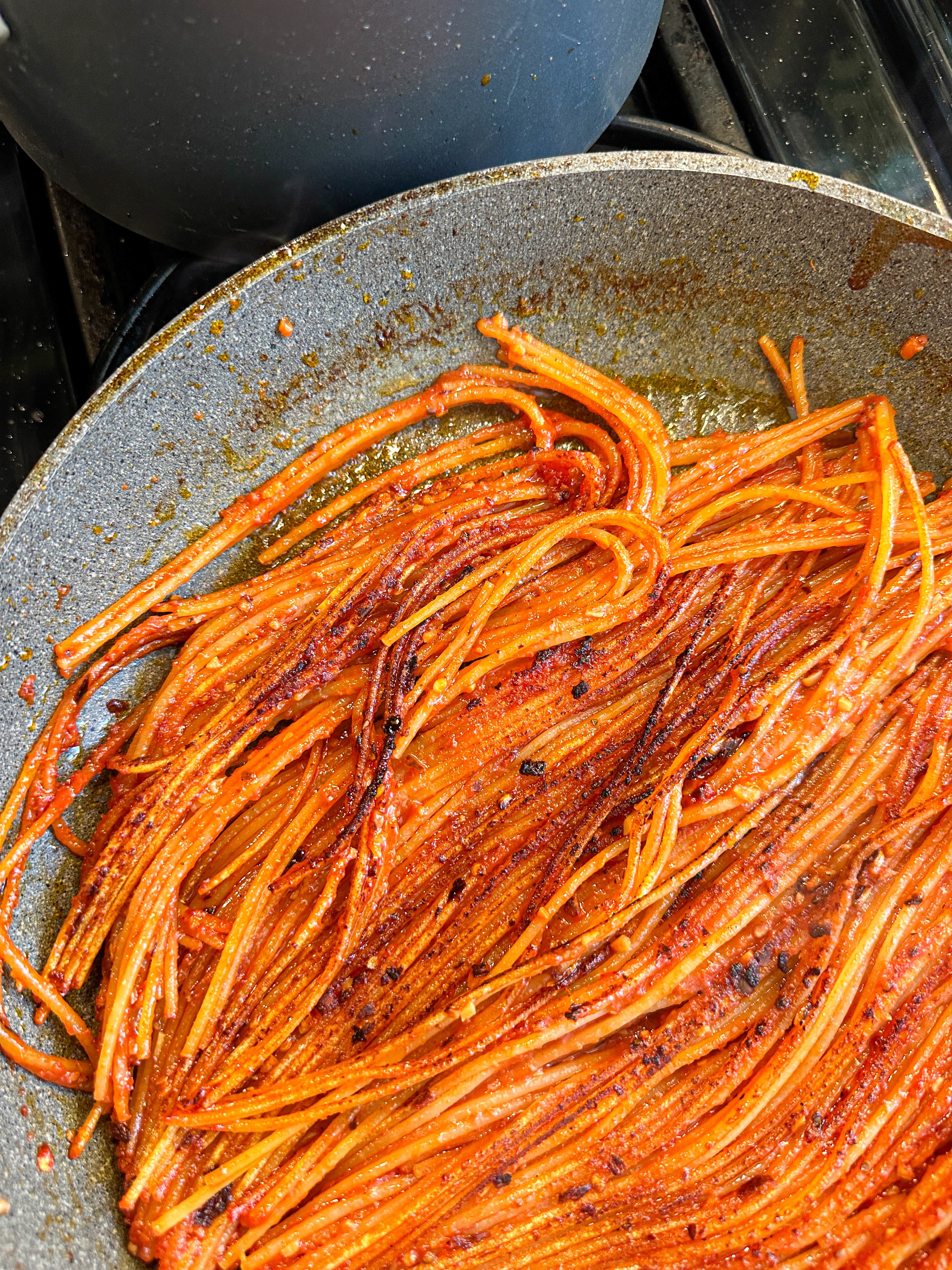 Charred spaghetti pieces in a skillet