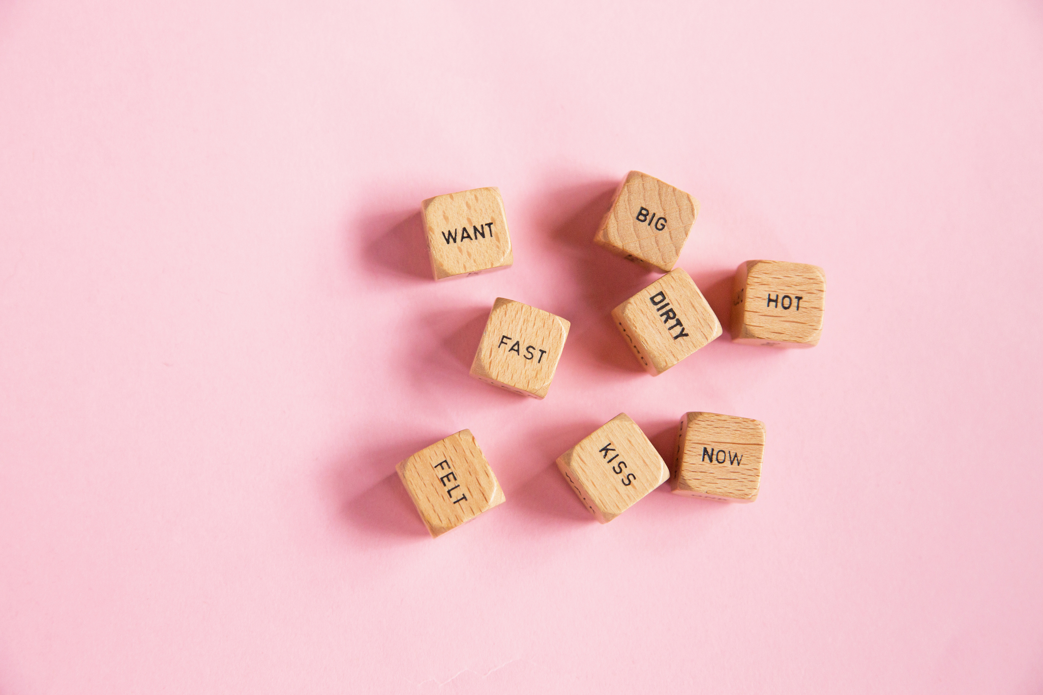 Wooden blocks with romantic and flirtatious words on a plain background
