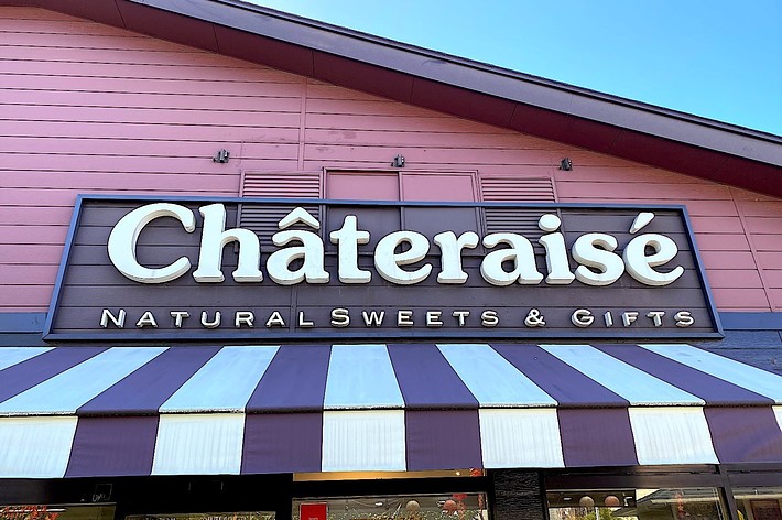 Storefront sign reading “Chateraise Naturals Sweets & Gifts” above striped awning