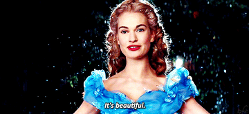 Ella from Cinderella in a blue dress, smiling and looking upwards as text says &quot;It&#x27;s beautiful.&quot;