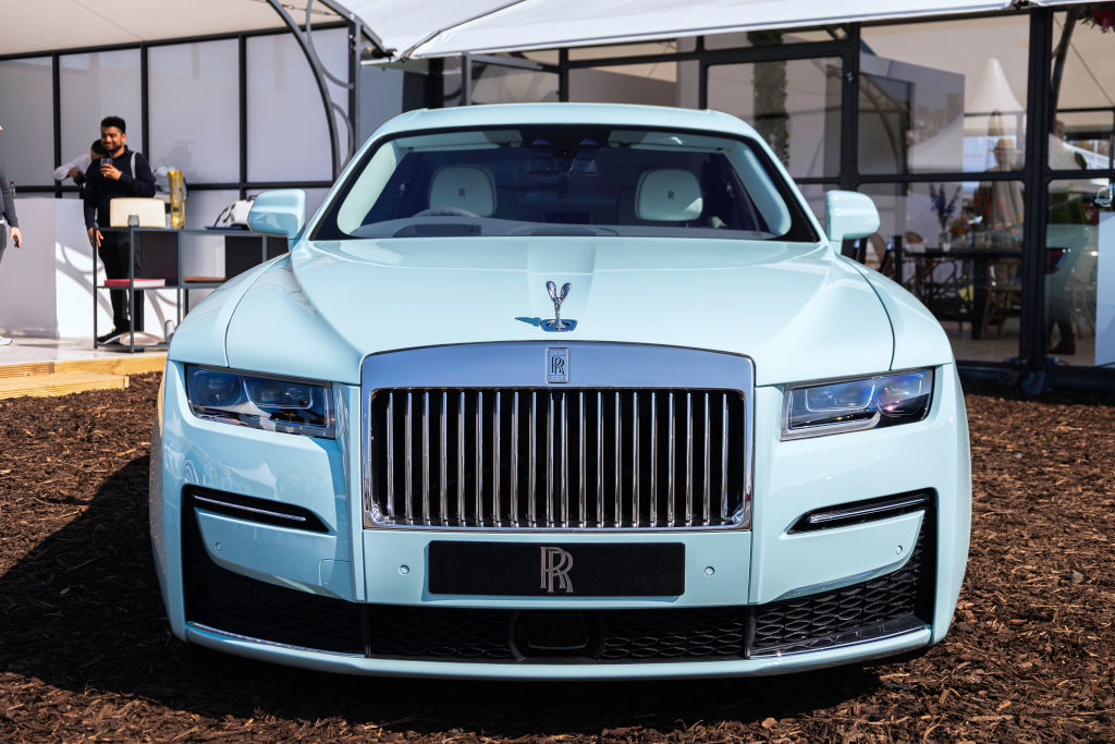 Front view of a Rolls-Royce car with a person standing in the background