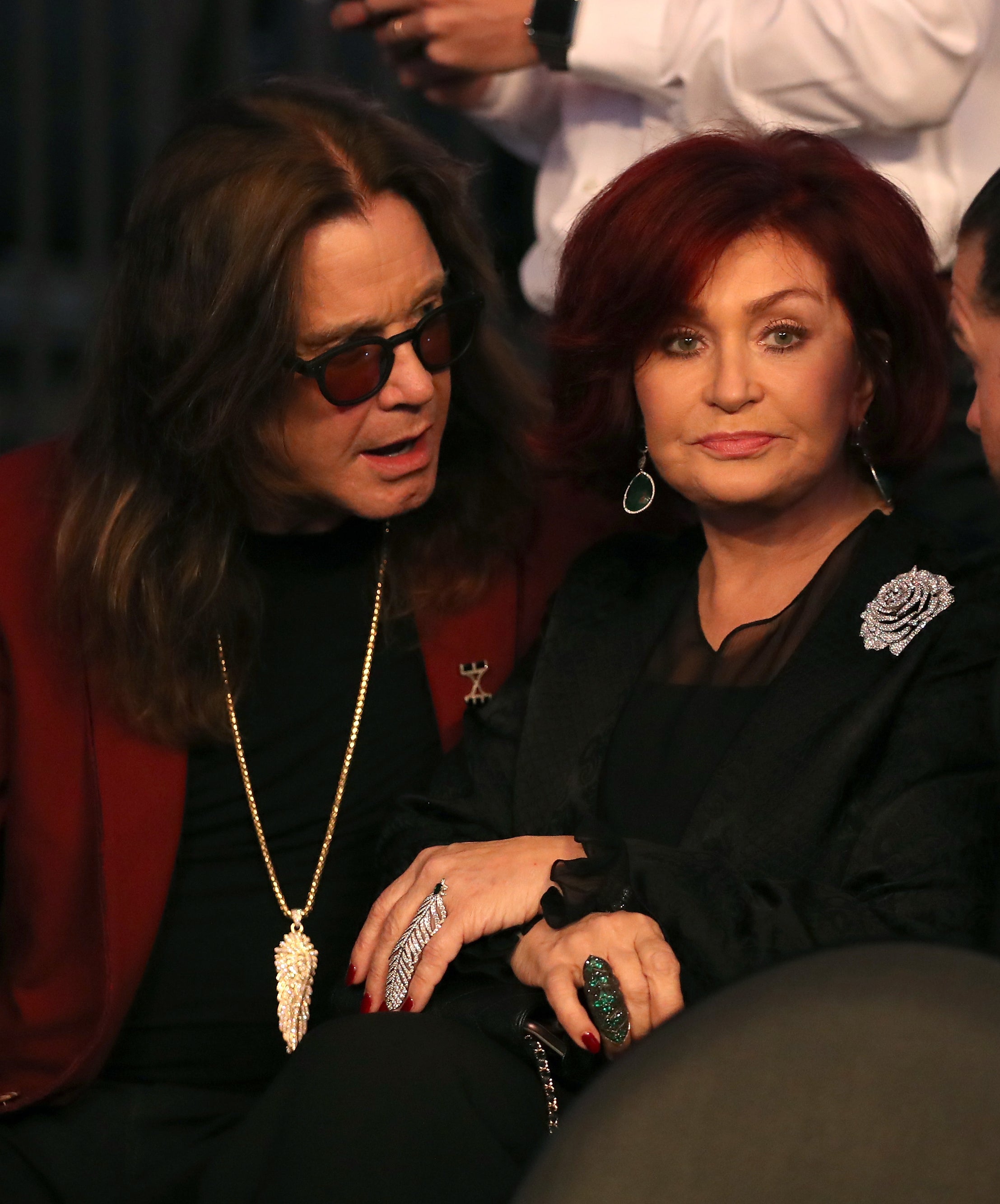 Ozzy Osbourne and Sharon Osbourne sit close together in conversation