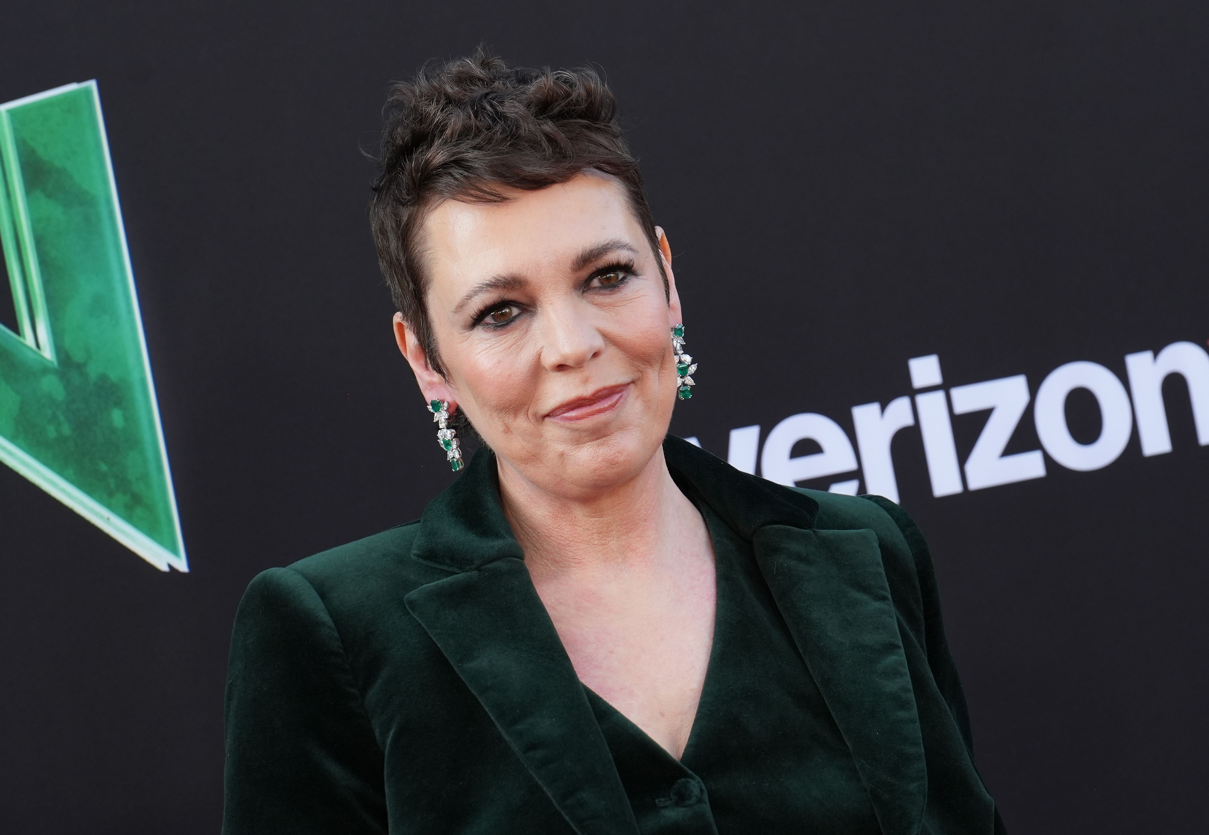 Olivia Colman in a velvet blazer with statement earrings at an event