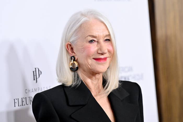 Helen Mirren poses at an event in a chic blazer and statement earrings