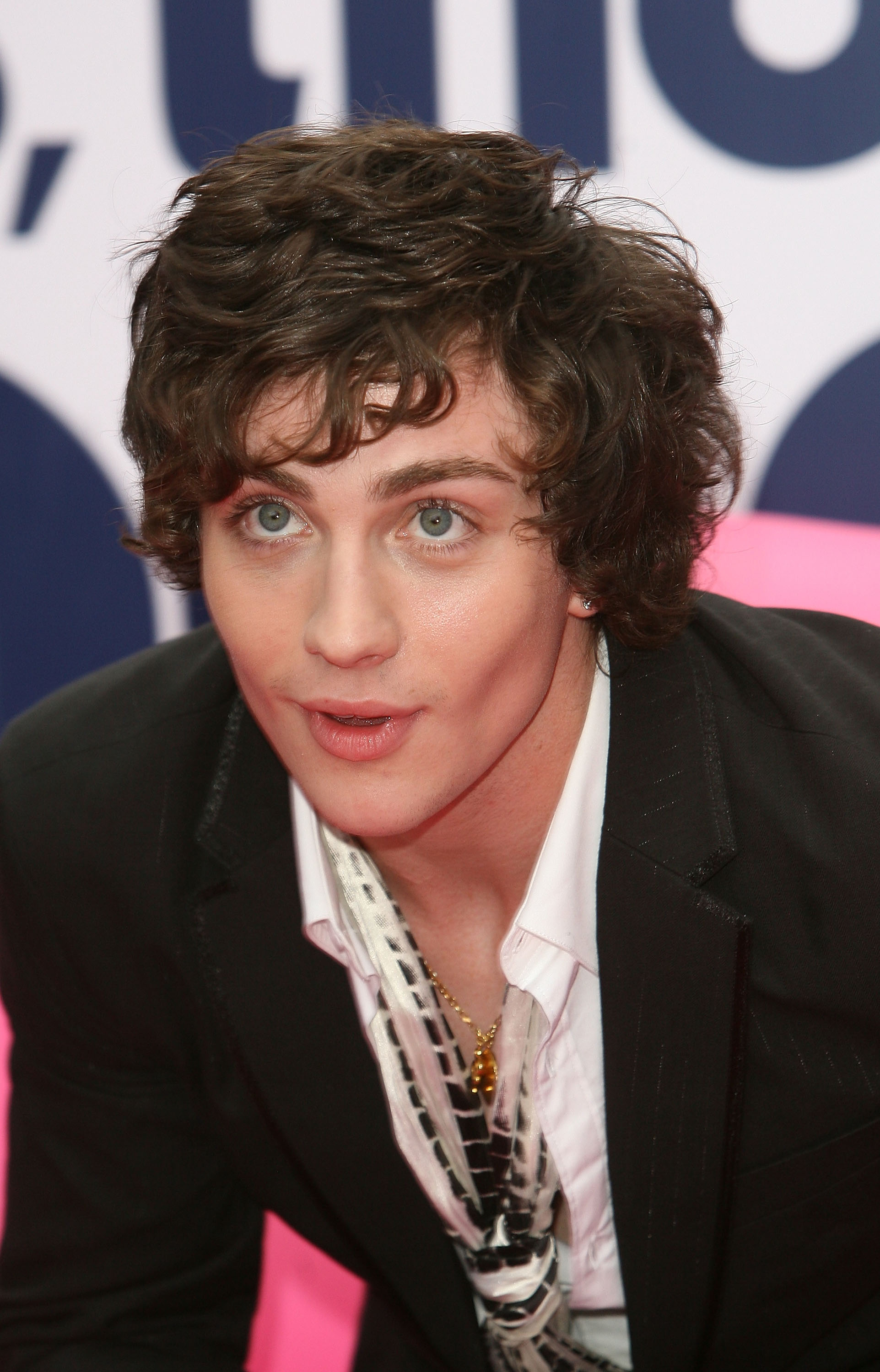 Aaron wearing a black blazer over a striped shirt at an event