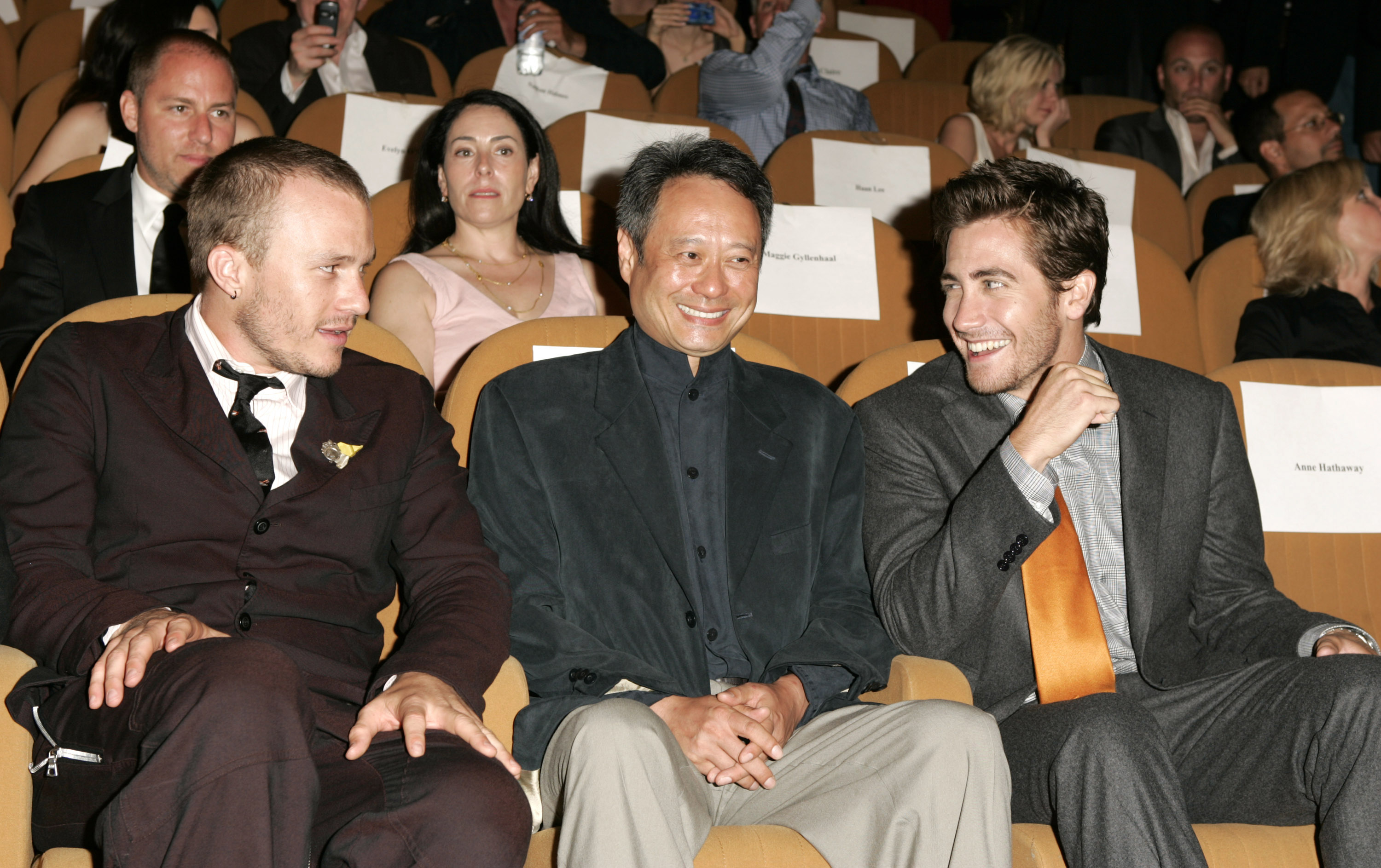 Heath and Jake, wearing ties, sitting with Brokeback Mountain director Ang Lee in a theater