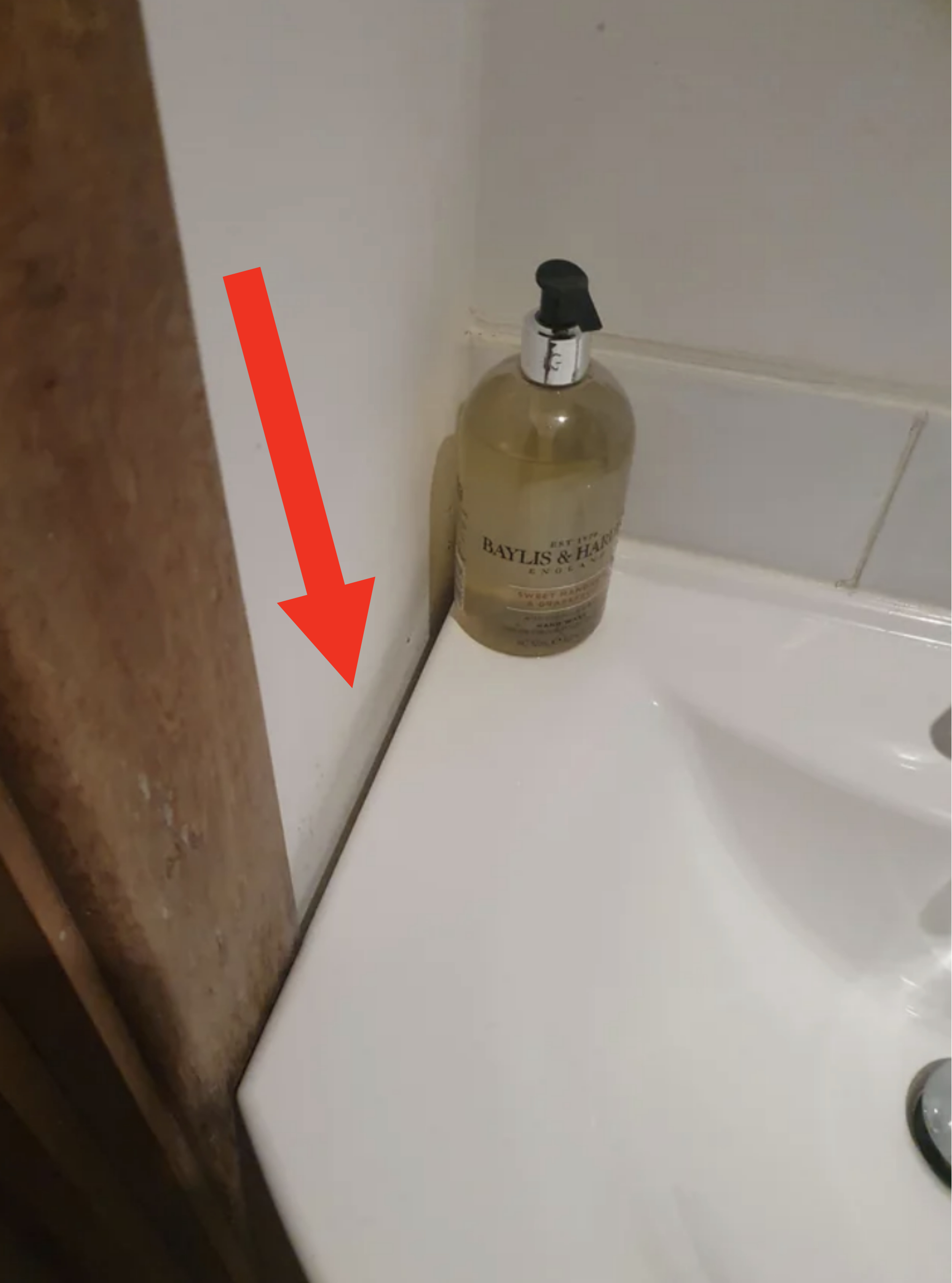 A bottle of Baylis &amp;amp; Harding liquid soap placed on the edge of a sink