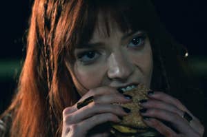 Anya Taylor Joy eating a burger as Margot in The Menu
