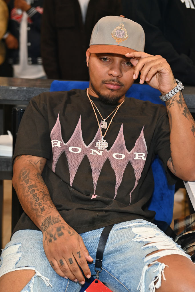closeup of bow wow sitting down and wearing a baseball cap