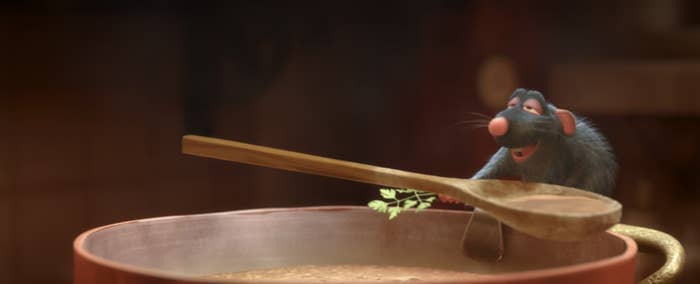 Animated rat Remy from Ratatouille perched on a pot edge with a spoon and a sprig of parsley
