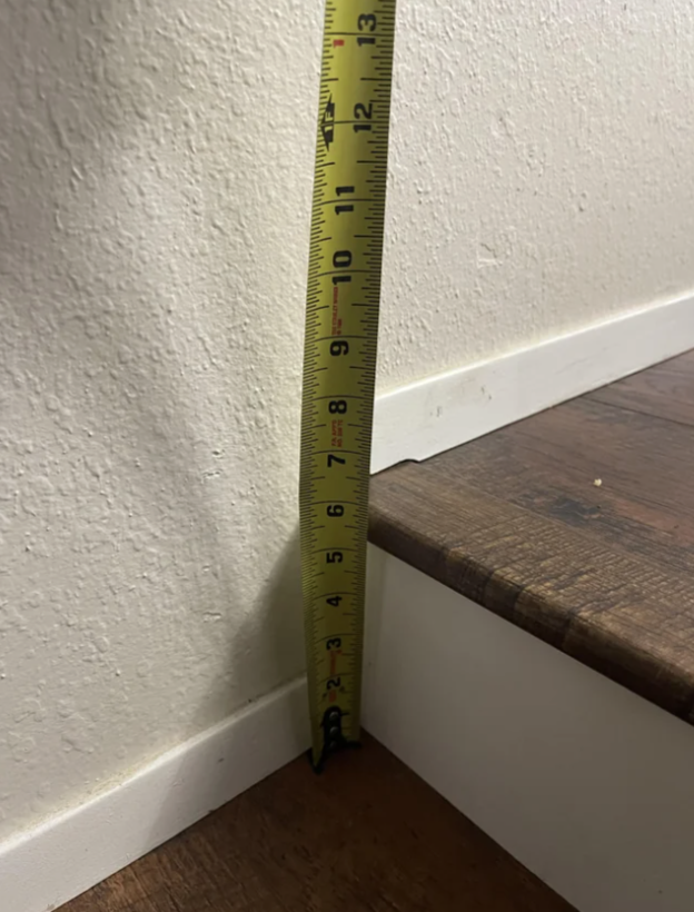 Tape measure against wall showing a step down of 6 inches from one room into the next