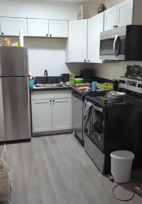 Kitchen with modern appliances and white cabinetry but no drawers