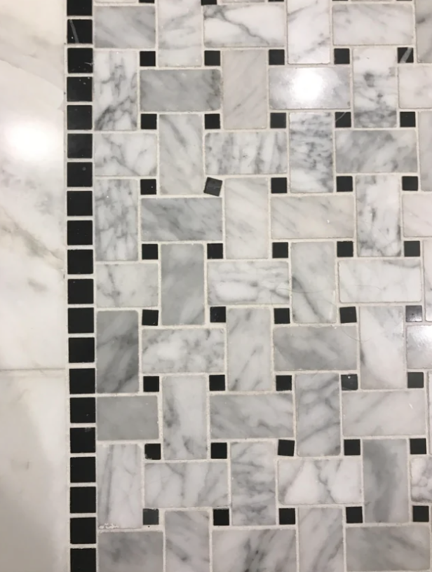 Marble floor tiles in a herringbone pattern with black accents