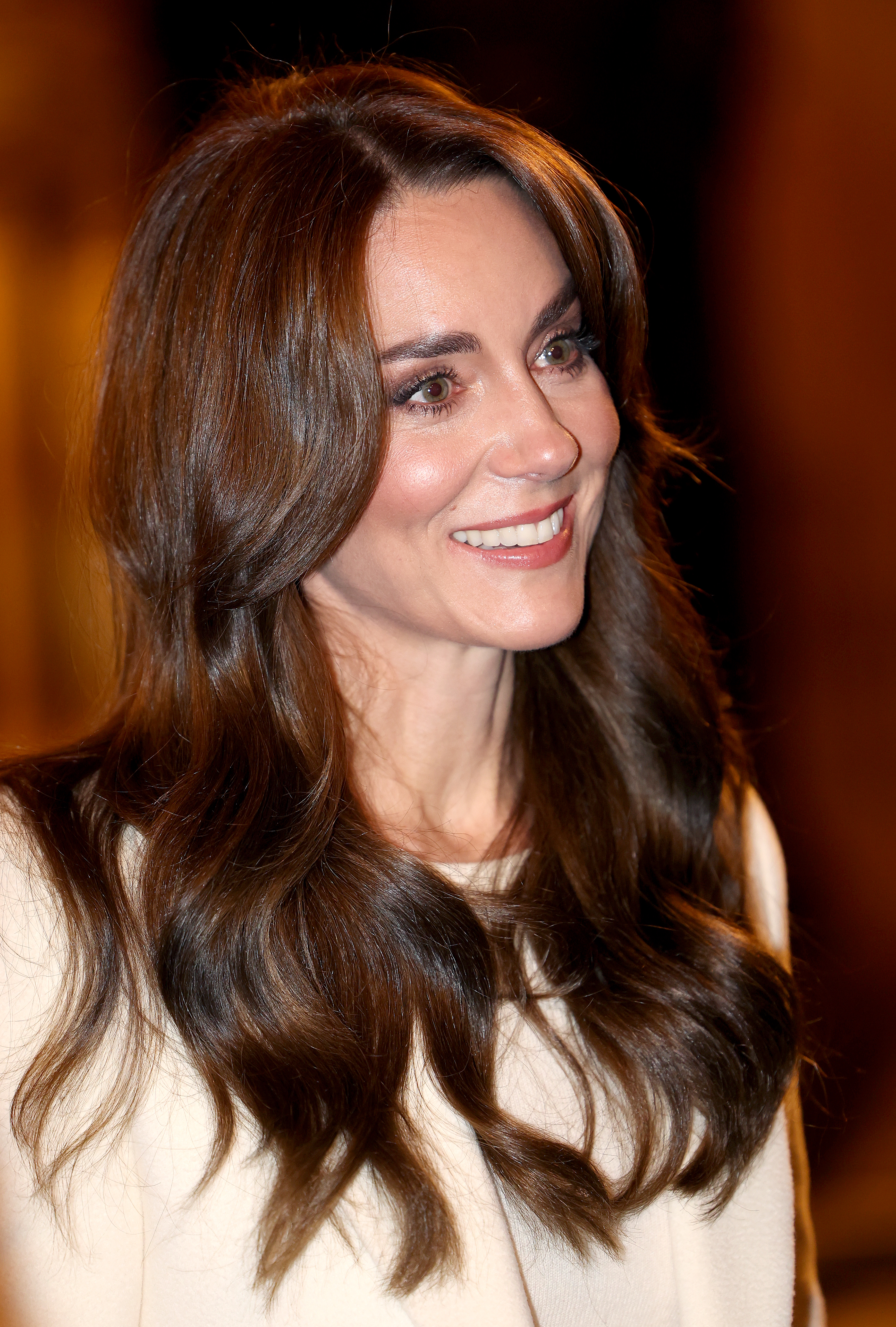 Close-up of a smiling Kate, wearing a light-colored top