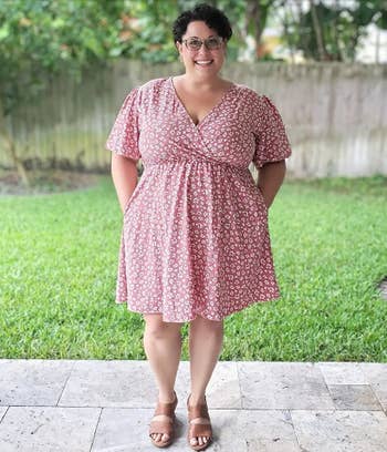 Reviewer in a floral dress and sandals smiling outdoors