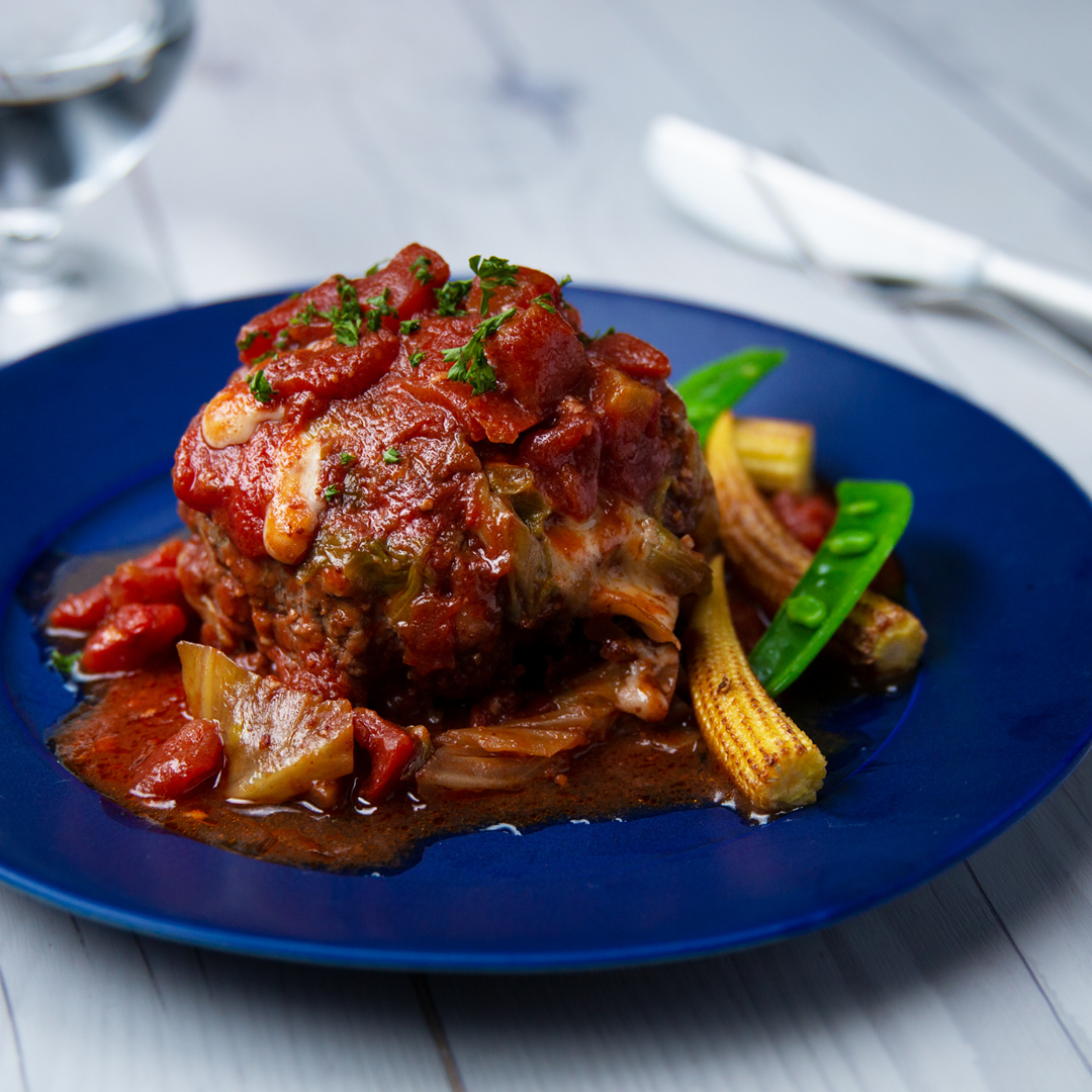 皿の上のトマトソースがかかったハンバーグ。