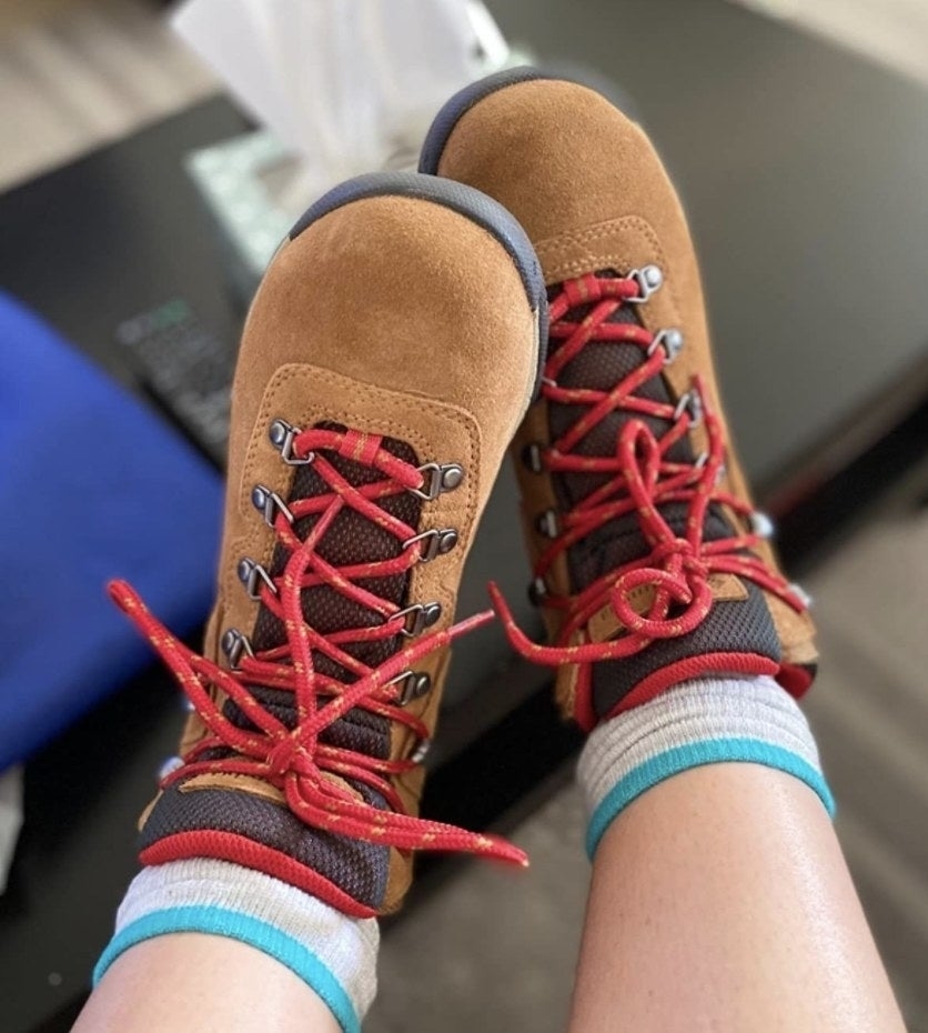 Person wearing hiking boots with red laces, viewed from above