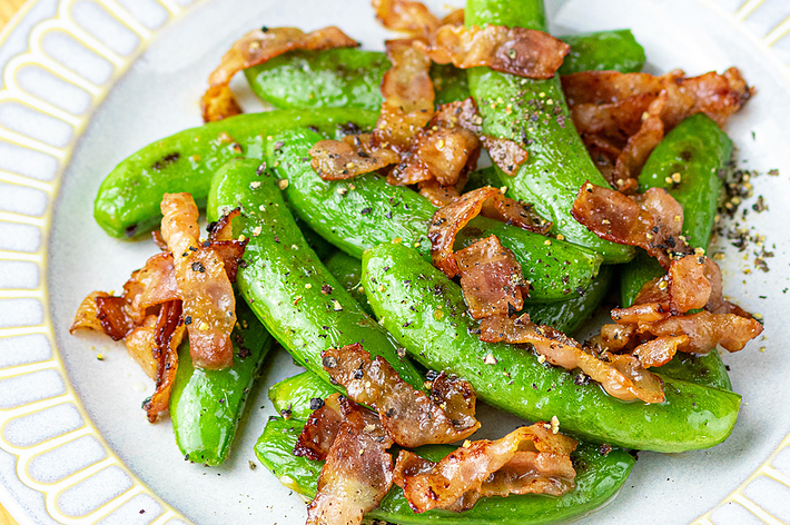 スナップエンドウとベーコンの料理が盛り付けられた皿。