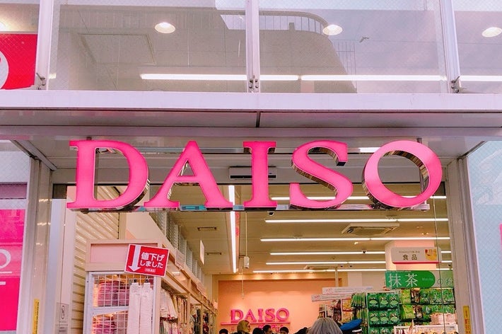 ダイソーの店頭で人々が買い物をしています。