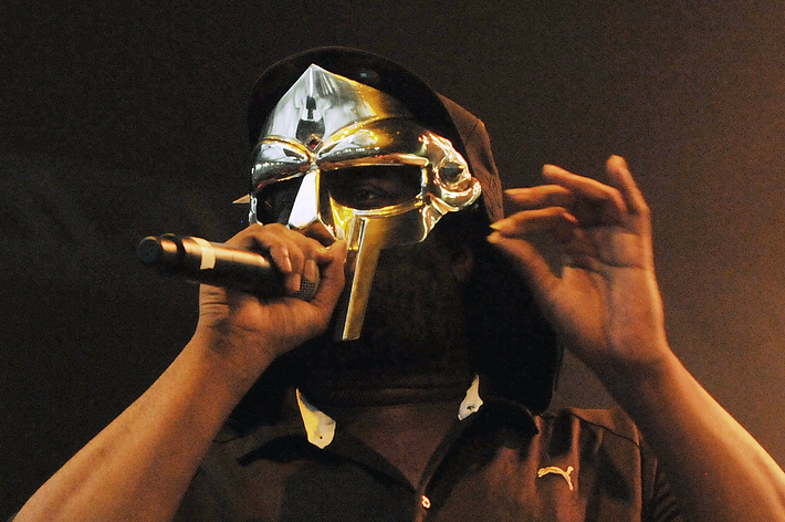 Person in a metallic mask performing with a microphone