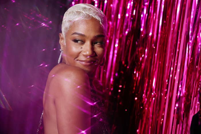 Tiffany Haddish in a glittery gown smiling over her shoulder against a sparkling backdrop
