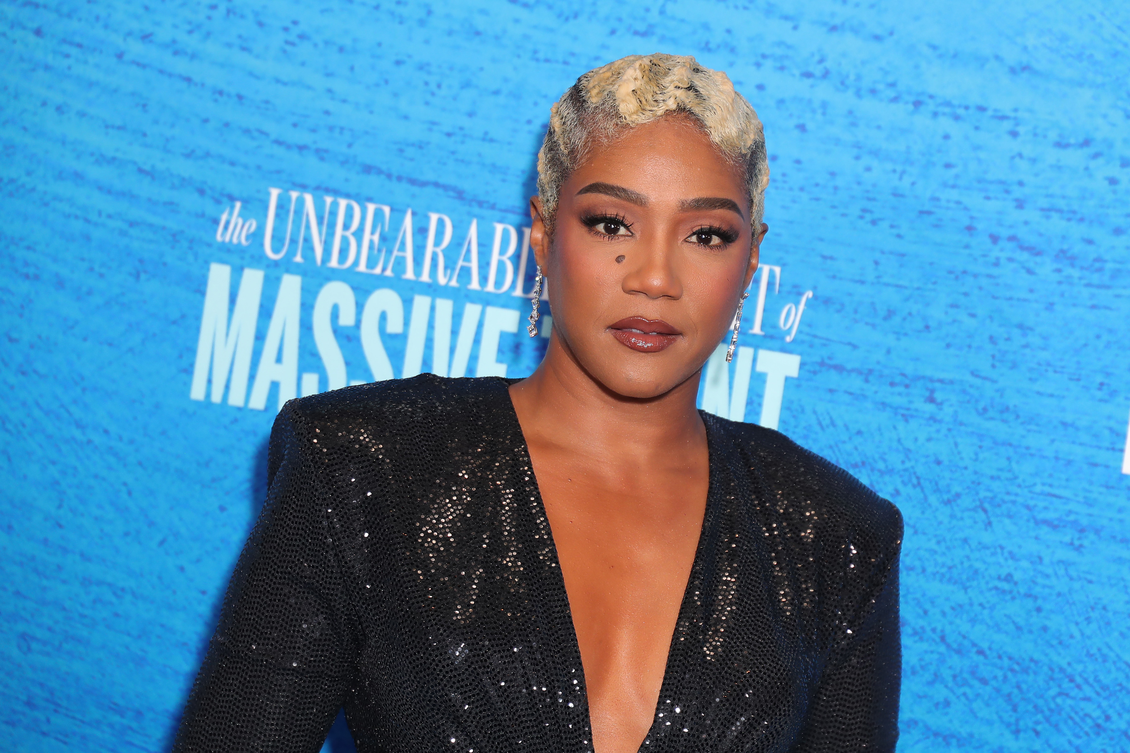 Tiffany Haddish poses in a black sequined dress with short blonde hair at an event