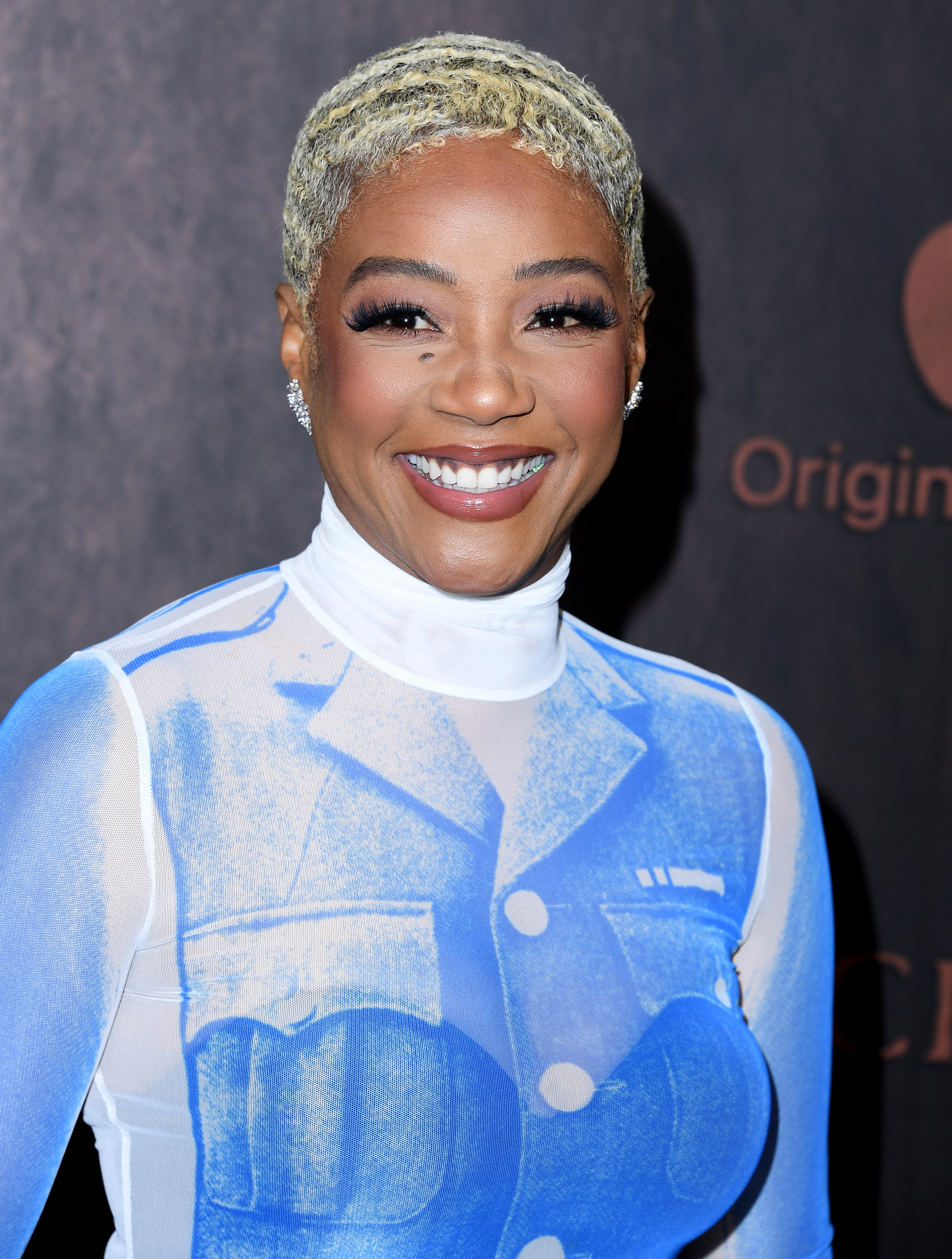 Tiffany Haddish in a graphic blue and white suit, smiling on the red carpet