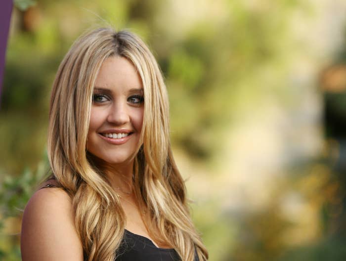 Woman with blonde hair wearing a V-neck top, smiling outdoors