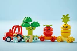 Toy figures with fruit and vegetable themed tops and a small toy truck