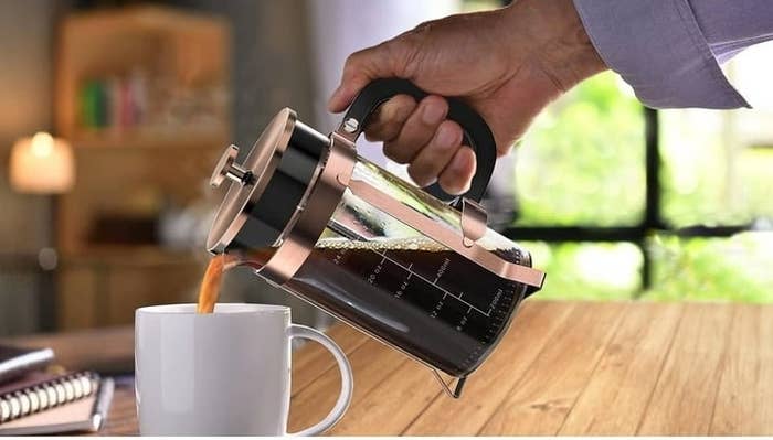 Person pouring coffee from a French press into a cup